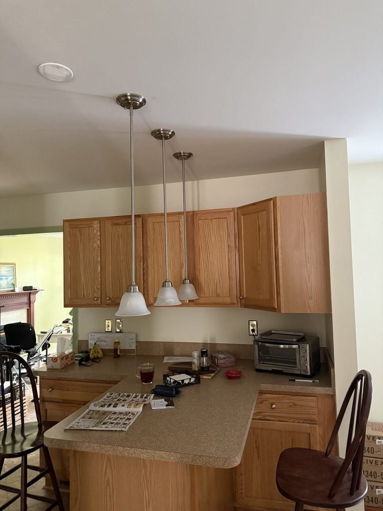 Three kitchen pendant lights installed over a breakfast counter in Severna Park, Anne Arundel County, MD